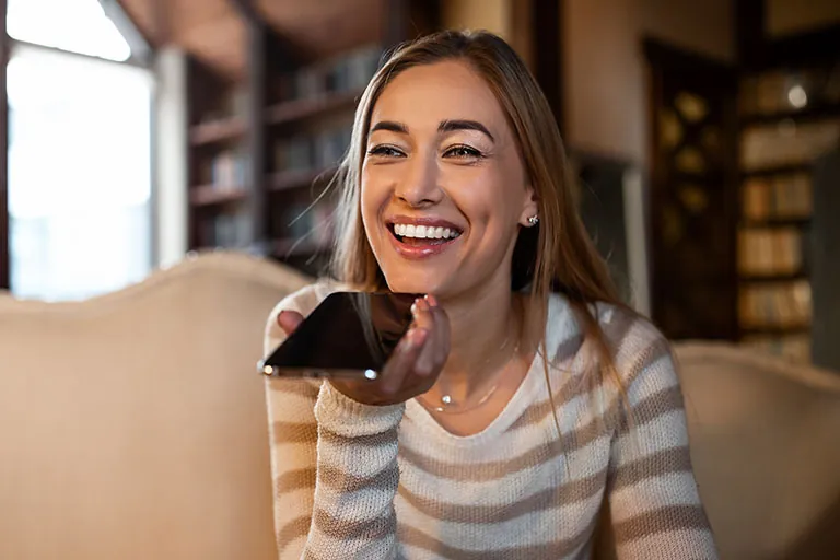 DeeLab, NLP Labeling, Closeup portrait of smiling woman holding cellphone near mouth using mobile voice recognition or digital assistance app speaking with virtual assistant, recording message talking on smartphone