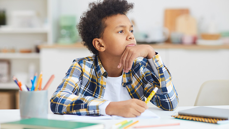 Deelab, Machine Learning, Deep Learning, Portrait of teenage African-American boy daydreaming at desk while doing homework, copy space.