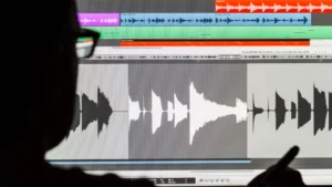 A man focused on segmenting audio files using specialized software, highlighting the meticulous process involved in audio data labeling.