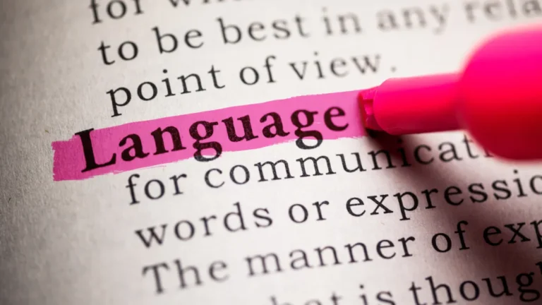 A close-up of a dictionary page with various words visible. The word 'Language' is highlighted with a colorful marker, representing the process of text labeling in data annotation and document processing for machine learning systems.